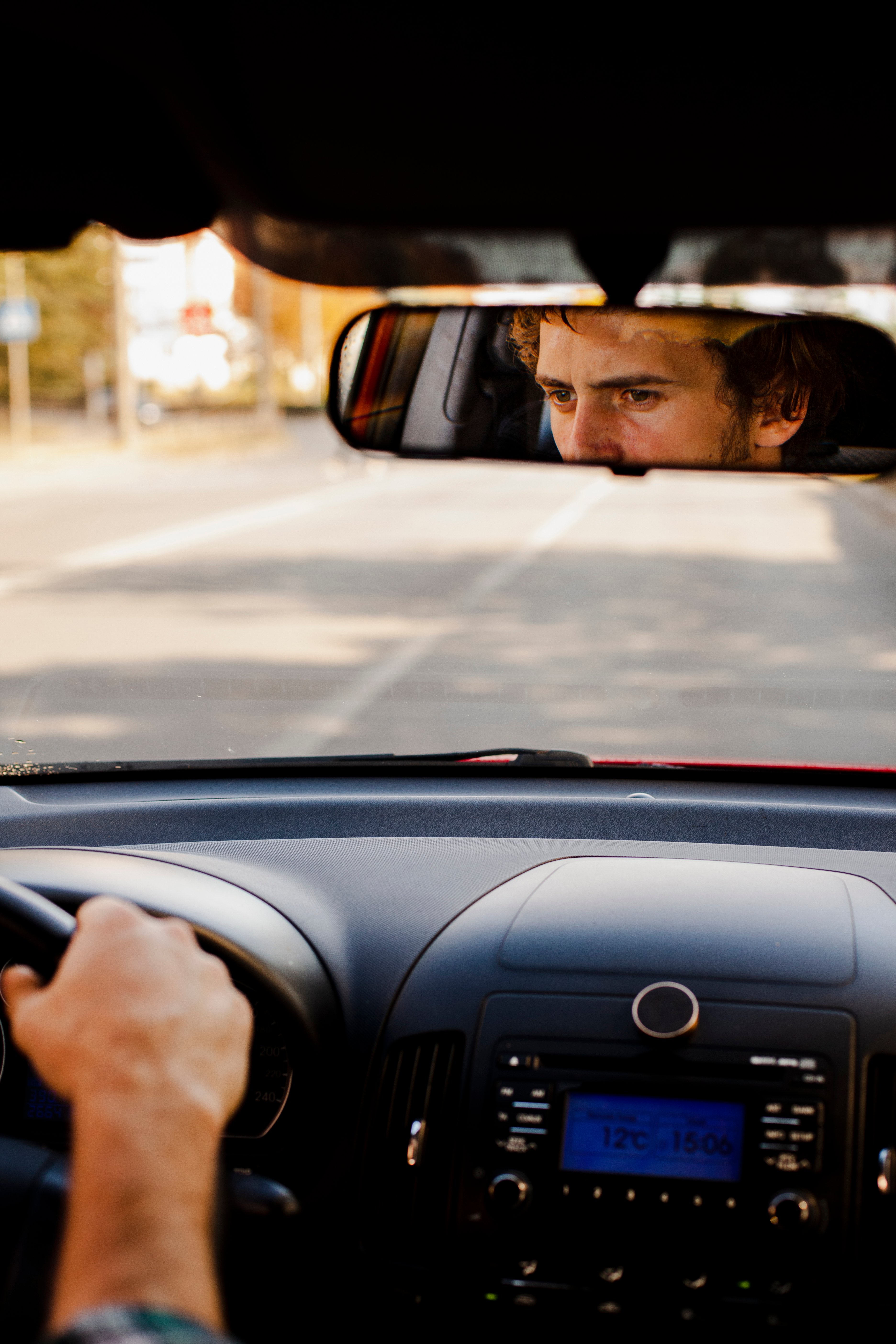 man-driving-car-seen-through-rearview-mirror